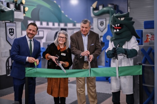 Ribbon cutting with green ribbon and mascot