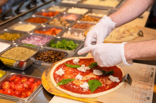a pizza cook prepares a pizza