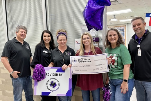 a group of Willis ISD teachers hold checks for grants