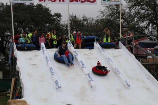 People sliding down a slope at Snowfest.