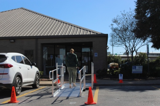 The photo shows a voter entering a Jersey Village municipal building.