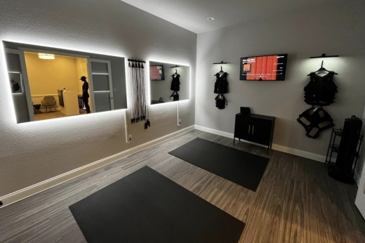 a workout center with mats on the ground and mirrors on the wall