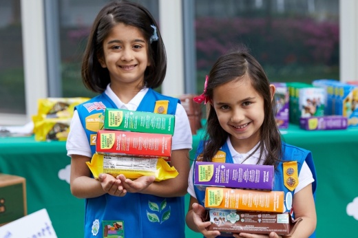 Two Girl Scouts holding boxes of cookies