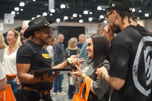 Three people smiles while sampling from a tray
