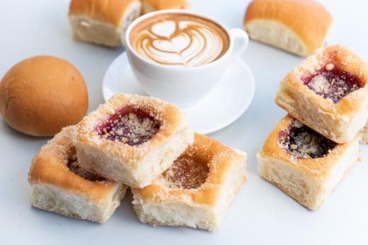 several fruit kolaches with a latte