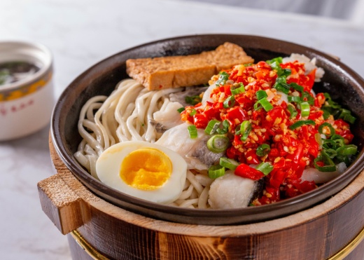 pot with noodles, hard-boiled egg and other toppings