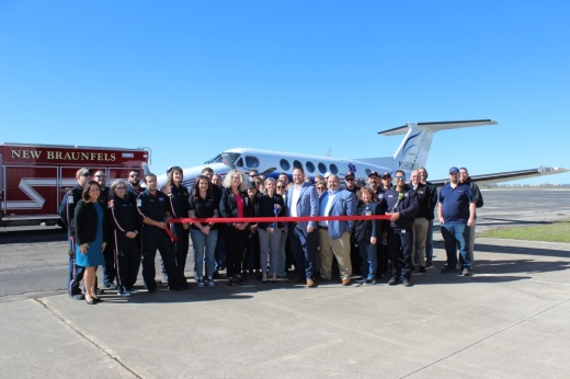 a group of people pose in front of an airplane