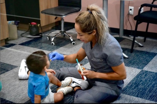 therapist sits with a child on the floor