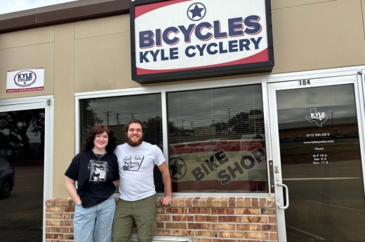 marc and rachael adams stand and smile in front of the kyle cyclery
