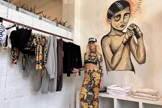 Business owner stands in front of a mural in her studio