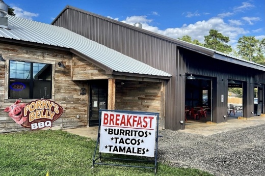 Porky's Belly BBQ is located 15496 FM 2854 in Montgomery. The building is constructed like a barn with open garage doors and a brick facade entrance and sign out front.
