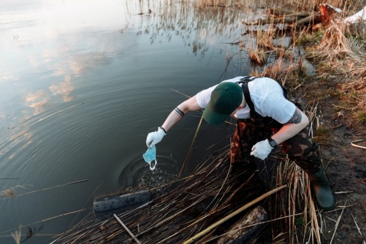 A man wades into a creek cleaning up trash and debris, like partners in the Adopt-A-Creek program in Pflugerville.