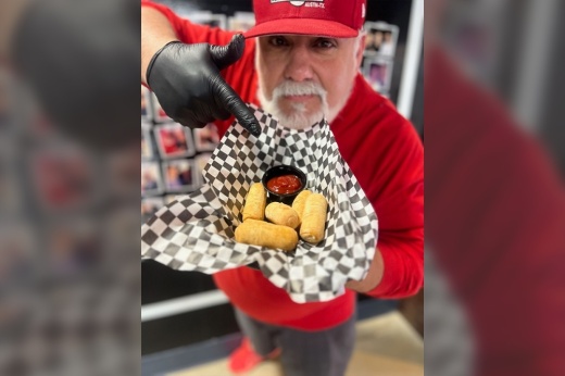 Chef Javi Maggiolo holds plate of cheese sticks