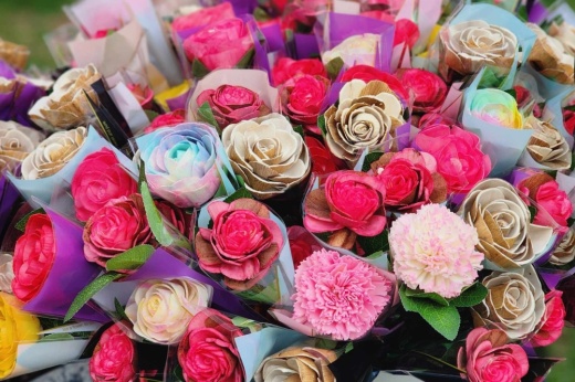 An up-close photo shows colorful, handmade, wooden flowers.