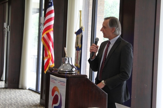 a man holds a microphone while standing at a podium
