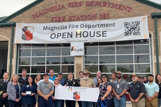 People posing for a photo in front of a fire station