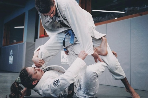two jiu jitsu students sparring on a mat