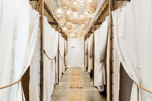 Hallway lined with white curtained rooms.