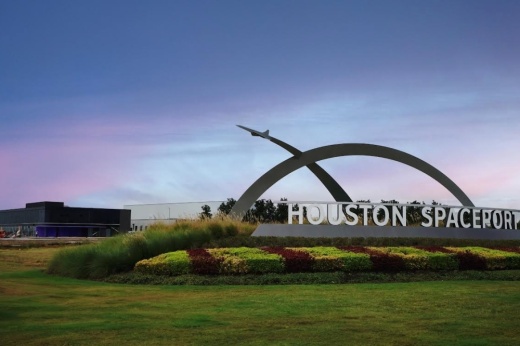 Intuitive Machines' new Lunar Production and Operations Center, in black, is seen behind the entrance sign to the Houston Spaceport.