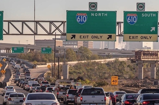 Heavy traffic sits on a highway under a sign for Loop 610