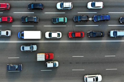 Cars sit in bumper-to-bumper traffic on one side of the road while some cars drive freely on the other side