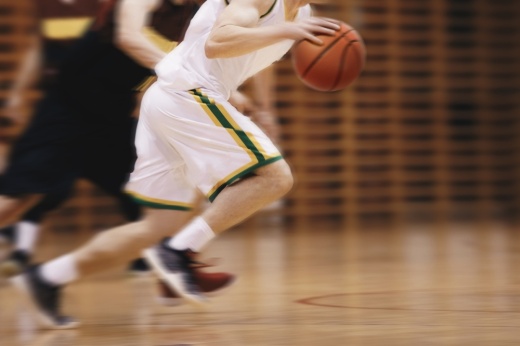 Two Young High School Basketball Players Playing Game. Youth Basketball Players Running in Motion Blur Durning Action. Basketball School Tournament. (Courtesy Adobe Stock)