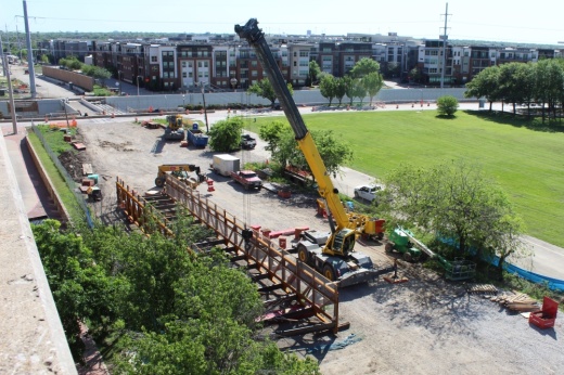 Construction crews work around a pedestrian bridge near Arapaho Road in Addison.