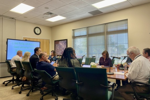 Board members sit around a table.