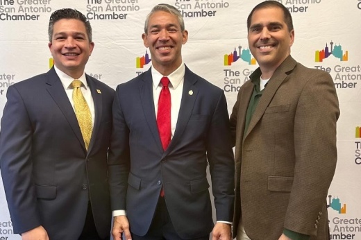 three men in suits pose together