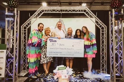 A group of people hold up a check