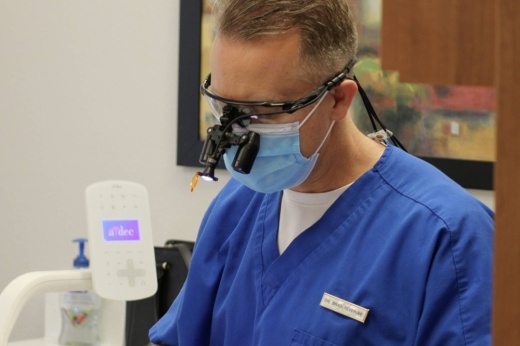 Male wearing blue scrubs, mask and medical procedure eyewear
