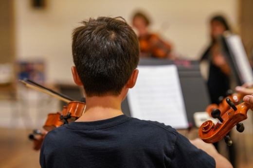 a young child plays the violin