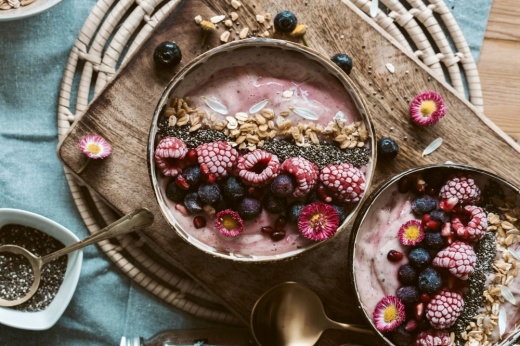 an acai bowl with berries and granola on a serving board