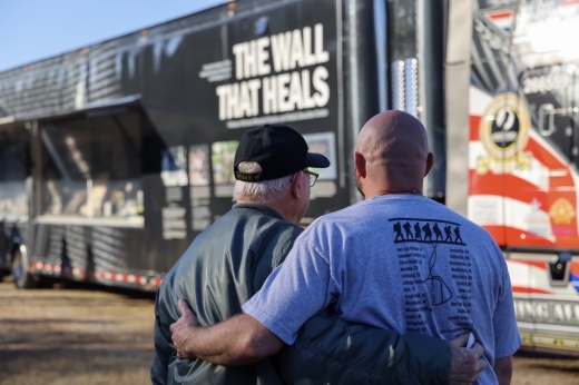 a picture of people looking at the Wall That Heals.