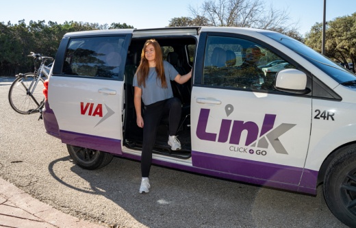 Woman getting out of a VIA Link van.