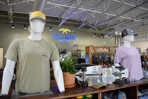Half-Moon Outfitters logo in the background of outdoor goods for sale