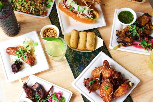 A table is filled with Laotian-American food.