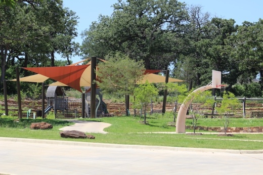Picture of a playground positioned next to a basketball court.