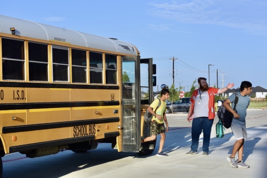 a group of students walk off a school bus