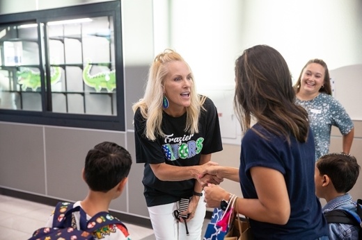 an elementary school principal shakes hands with a parent