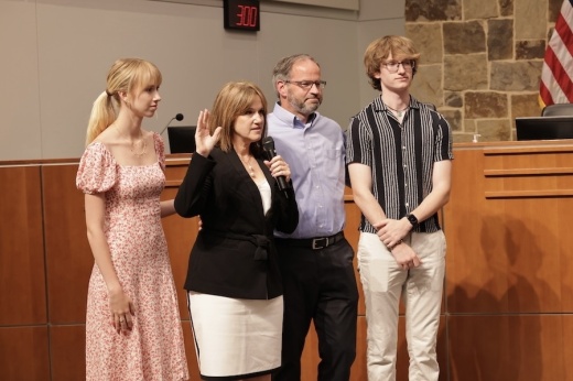 Picture of a woman taking the oath of office at a town council meeting.