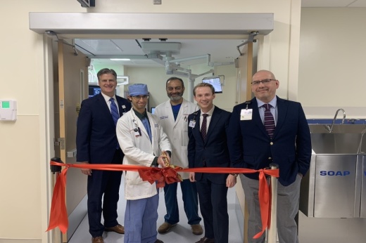 five men cut a ribbon inside a hospital unit