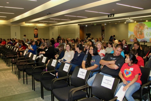 A shot of a room filled with commuting members waiting to speak at a Houston ISD board meeting