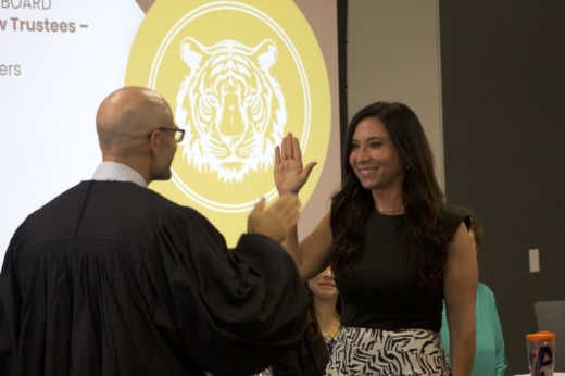 Shanda DeLeon raises her right hand to take an oath with a judge