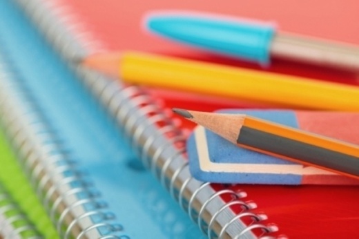 A stack of notebooks with pencils.