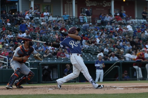 A baseball player hits a ball.