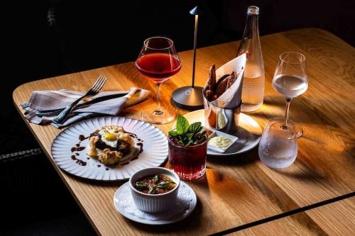A glass of wine, food and other items on a table.
