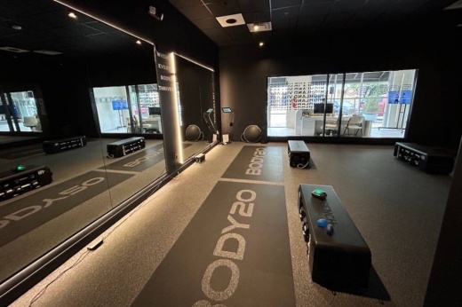 Room with mirrors on the wall and Body20 exercise mats on the ground.