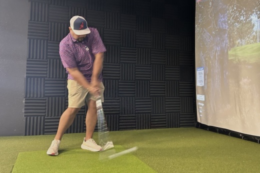 Co-owner Jordan Ramirez using one of the golf simulator bays