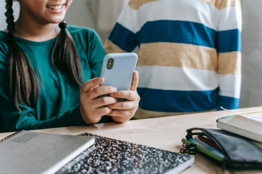 A student is on her phone sitting at a desk